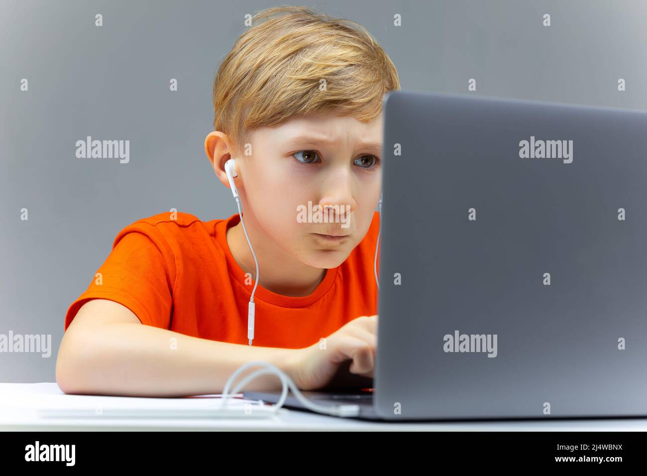 Online learning at home boy sitting at laptops and typing stock photo