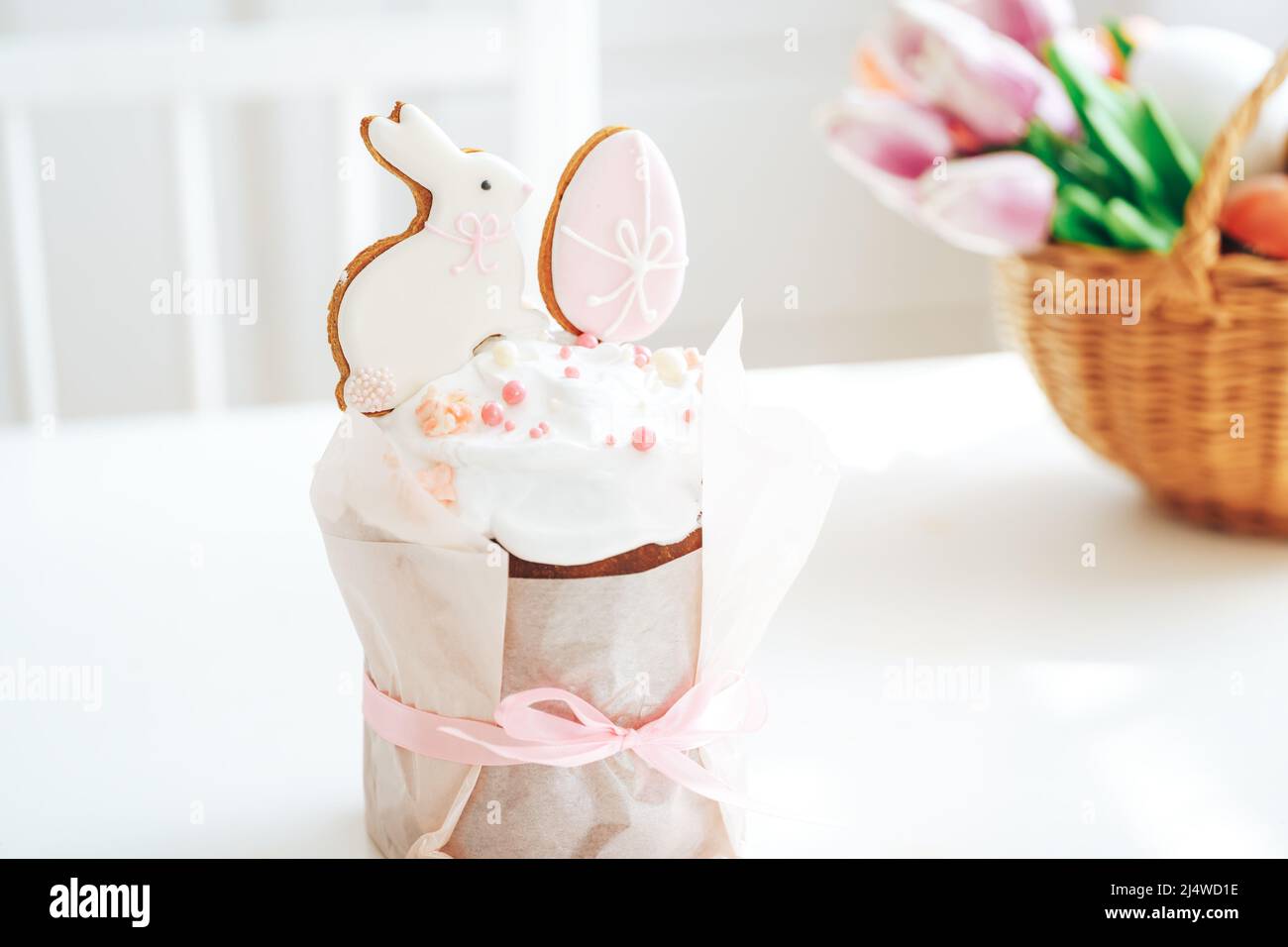 Cookies in the form of rabbit and an egg on easter cake tied with bow Stock Photo