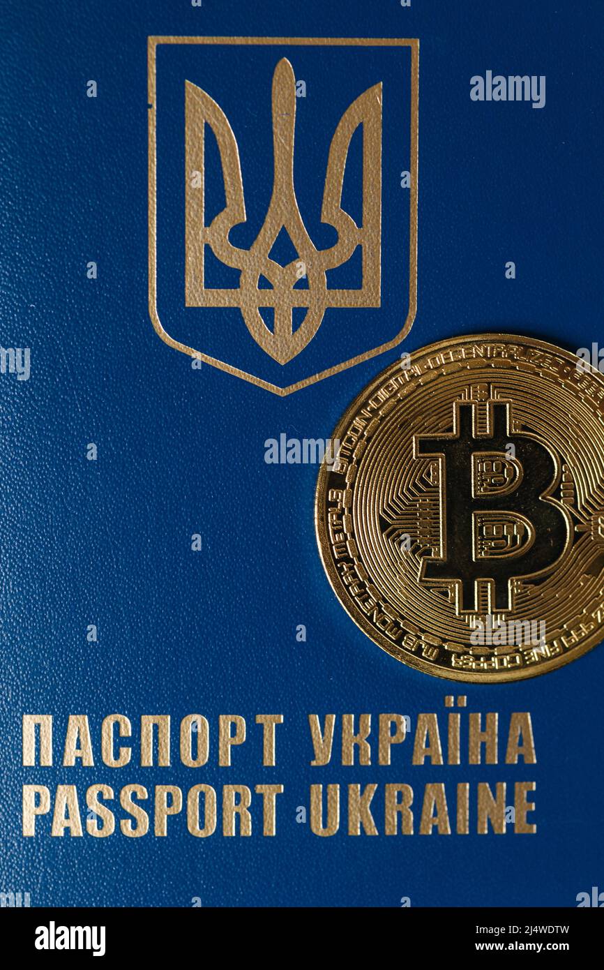 Close-up of Urkaine passport with bitcoin golden coin. Urkaine currency during the war. Virtual money Stock Photo