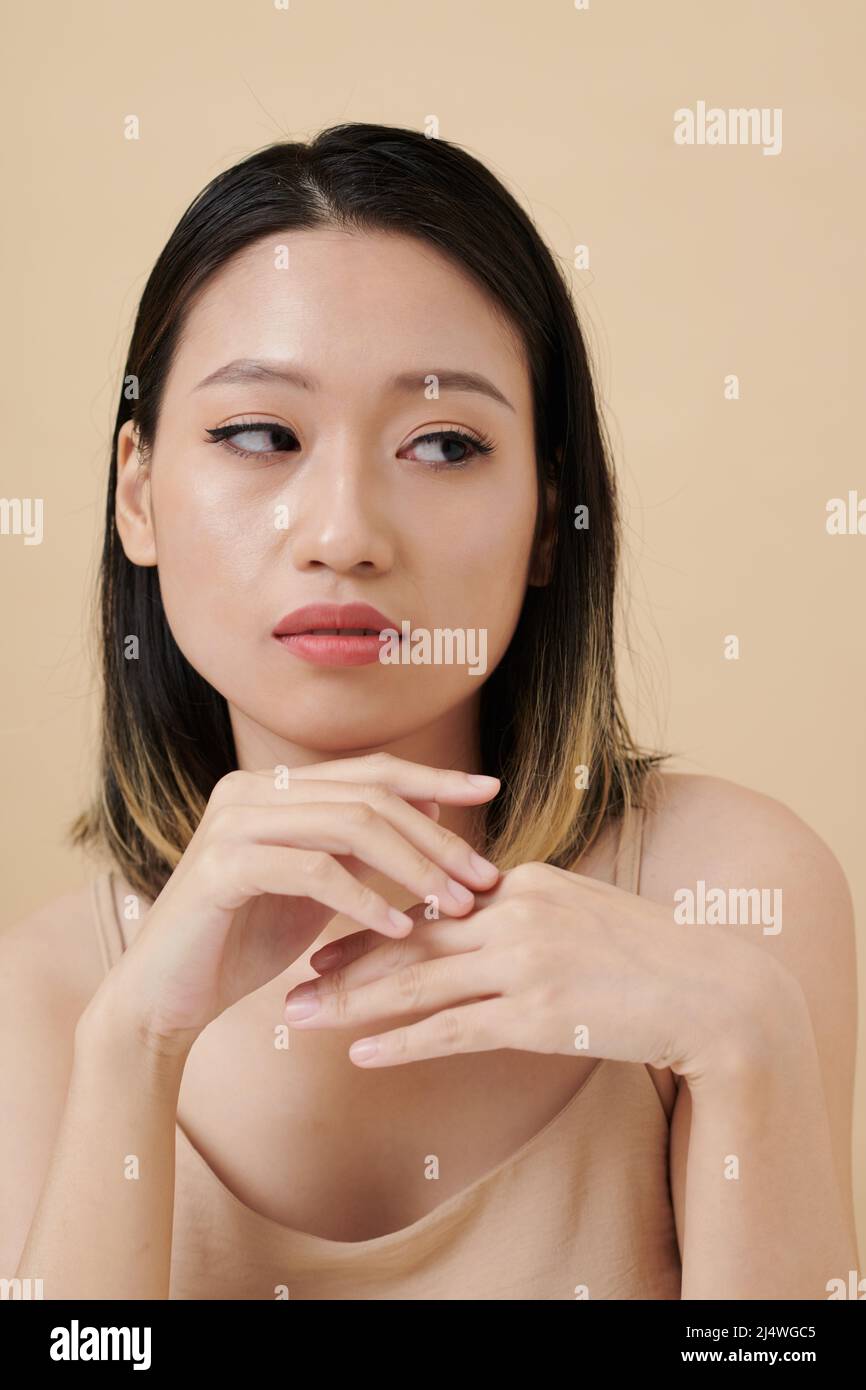 Face of envious or arrogant young Asian woman looking away Stock Photo