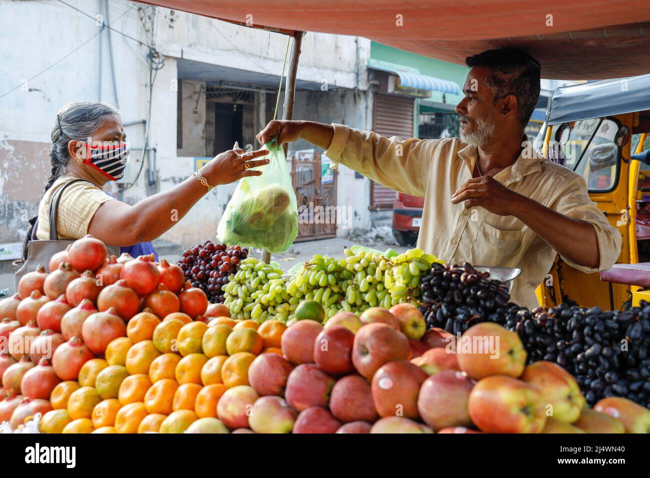 Man selling fruit from his roadside cart in Trichy, Tamil Nadu, India