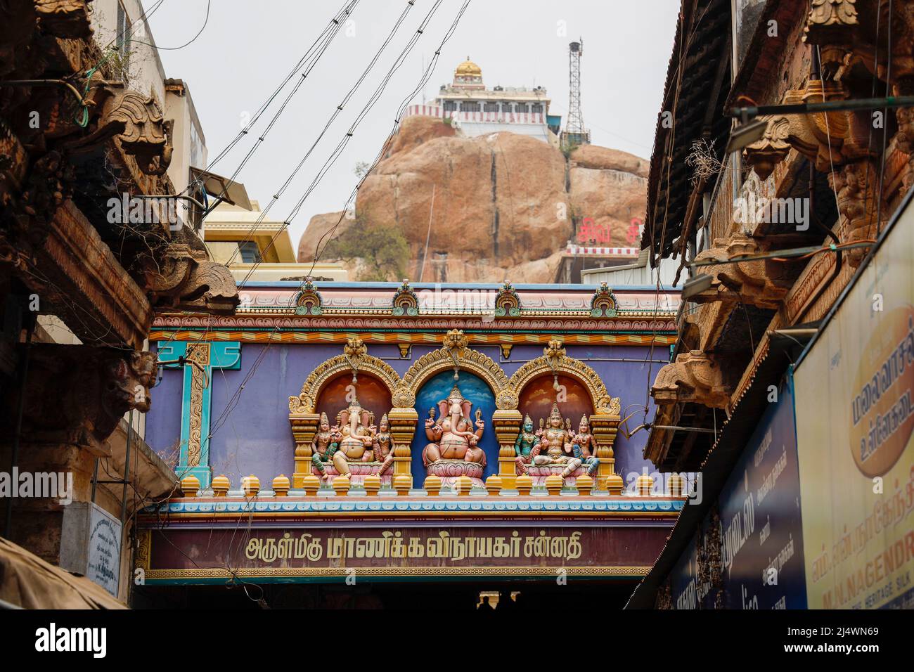 In the foreground  entrance to the Ganesha Temple (Manicka Vinayagar Temple, Malaikottai), in the background the 7th century Rockfort Temple (Arulmigu Stock Photo