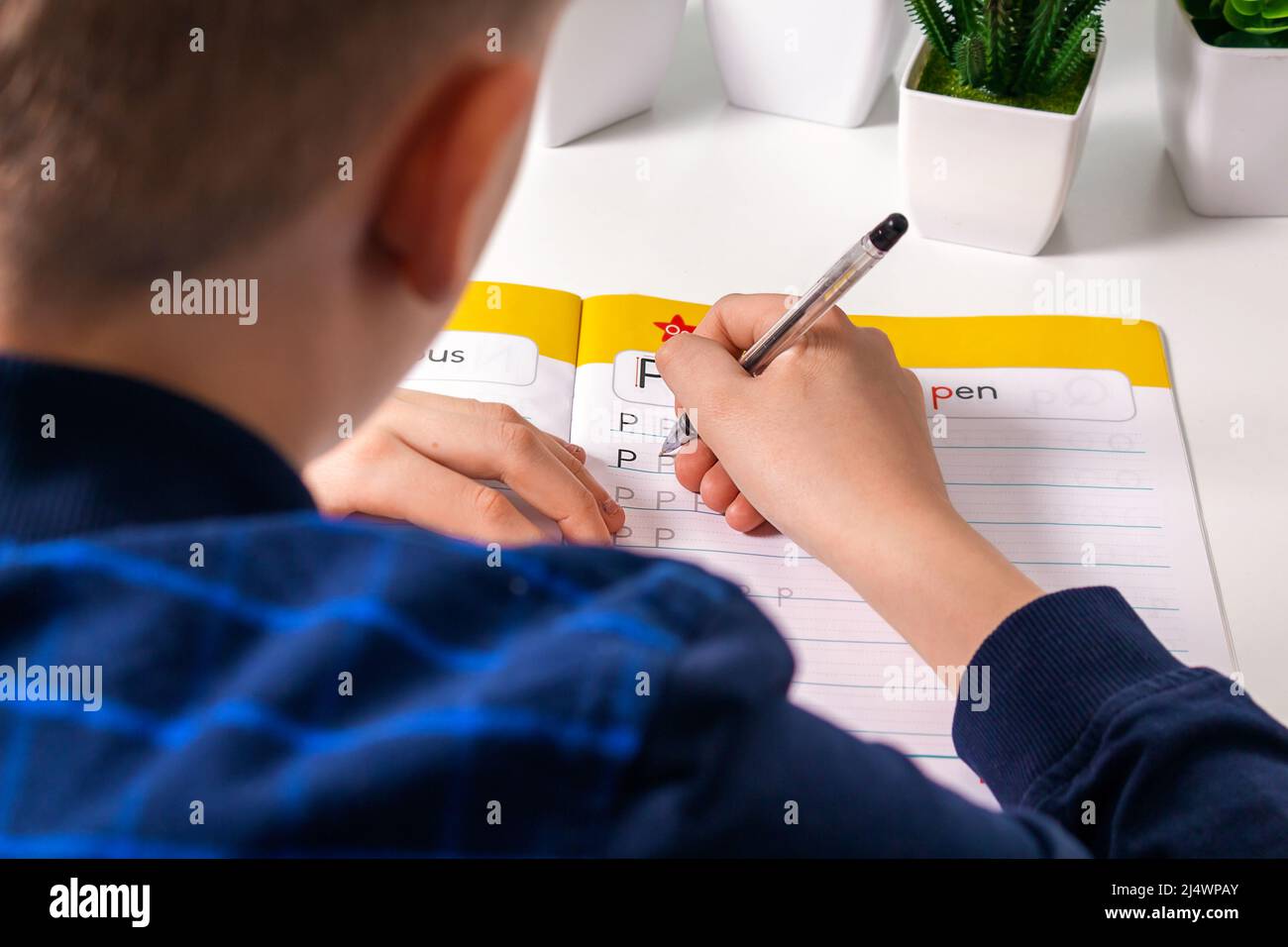 Teenager doing homework sitting at white desk Stock Photo Alamy