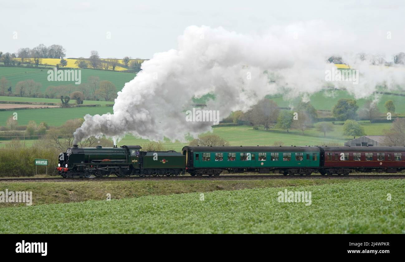 The SR V Schools class steam locomotive Cheltenham makes it's way along the Mid Hants Railway, also known as the Watercress line, near to Ropley in Hampshire. Picture date: Monday April 18, 2022. Stock Photo