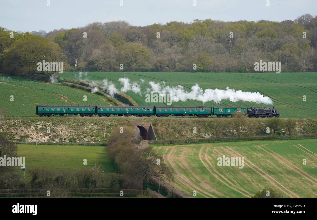 British Railways Ivatt Class 2MT Tank Engine number 41312 makes it's way along the Mid Hants Railway, also known as the Watercress line, near to Ropley in Hampshire. Picture date: Monday April 18, 2022. Stock Photo