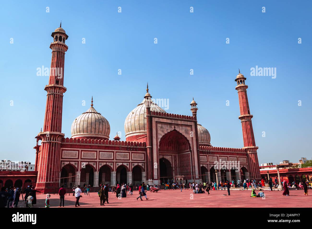 ancient mosque with people and bright blue sky at morning from unique perspective image is taken at jama masjid delhi india on Mar 30 2022. Stock Photo