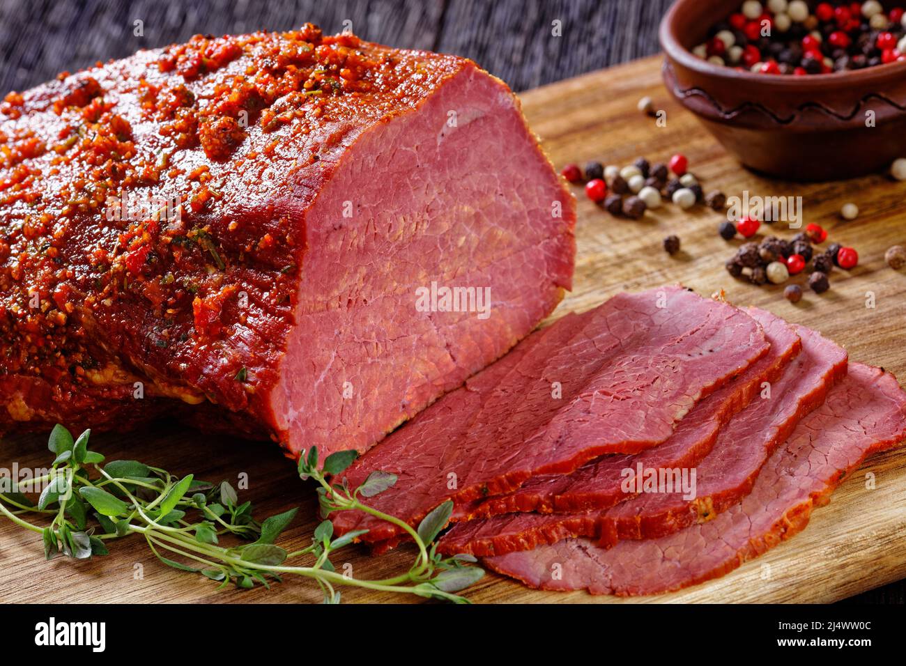 close-up of roast beef pastrami on wooden board with fresh rosemary, thymes  and pickles on dark table, horizontal view from above Stock Photo - Alamy