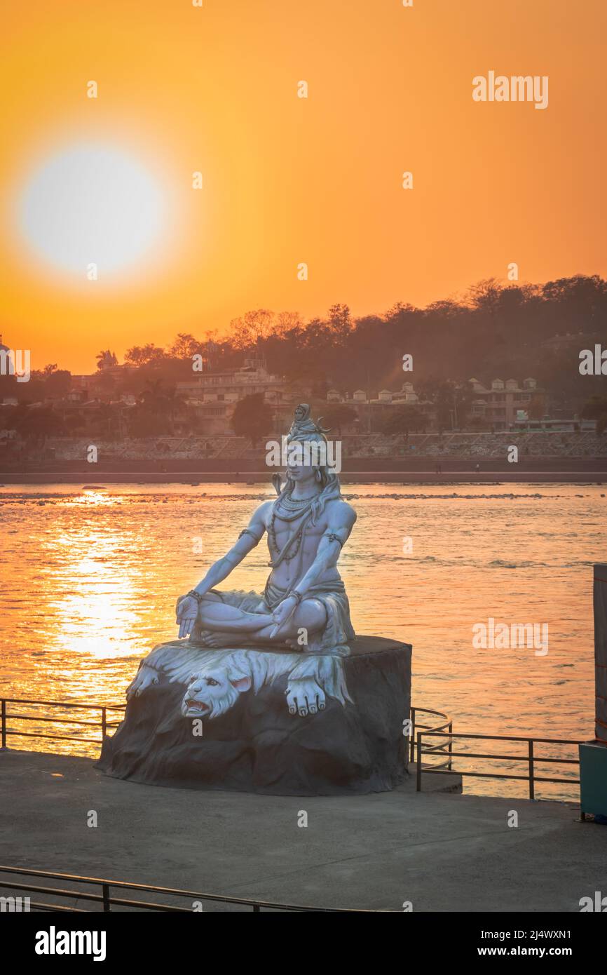 hindu god lord shiva statue in meditation posture with dramatic sky at evening from unique angle image is taken at parmarth niketan rishikesh uttrakha Stock Photo