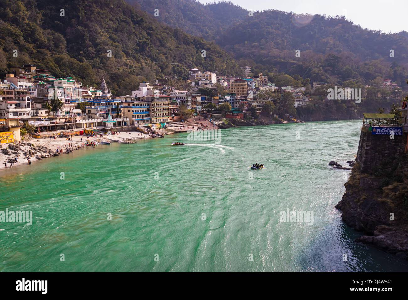 city at river bank with mountain background at day from flat angle image is taken at rishikesh uttrakhand india on Mar 15 2022. Stock Photo