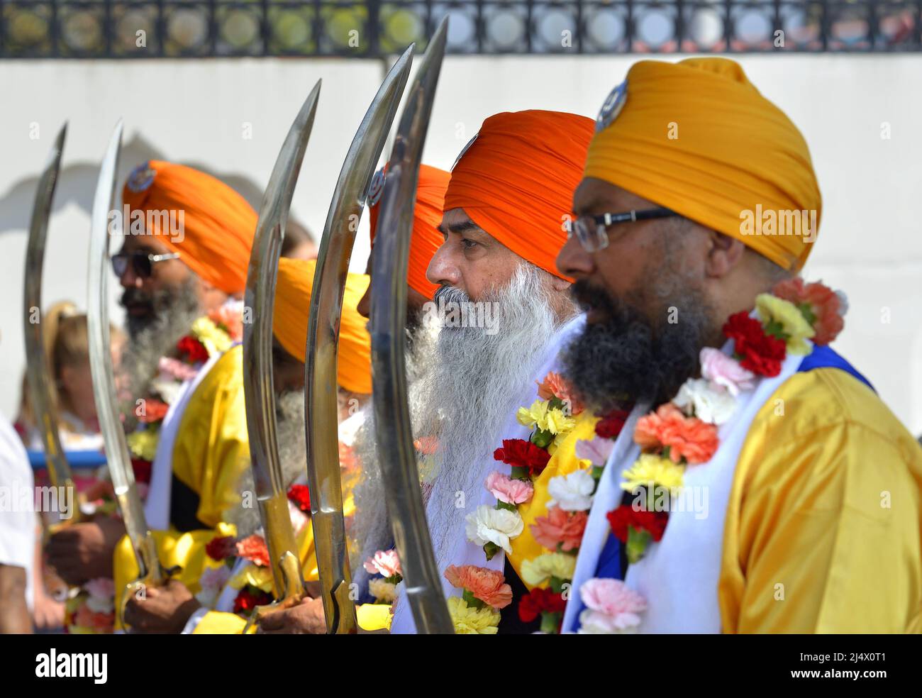 Sikh men wearing the traditional dastar (turban) and carrying the ceremonial talwar (sword) as members of Gravesend's large Sikh community process.... Stock Photo