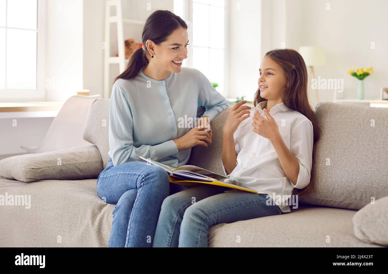 Happy mother and daughter discussing story from book that they have read together Stock Photo