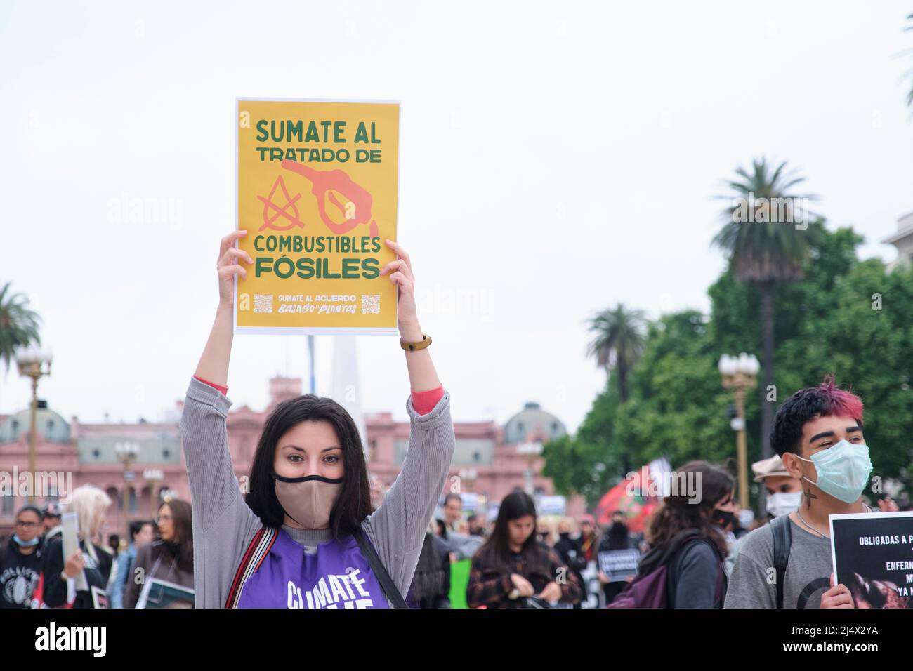 Buenos Aires, Argentina; Nov 1, 2021: World Vegan Day. Young people protesting in Plaza de Mayo. Woman raising a poster: Join the fossil fuel treaty. Stock Photo