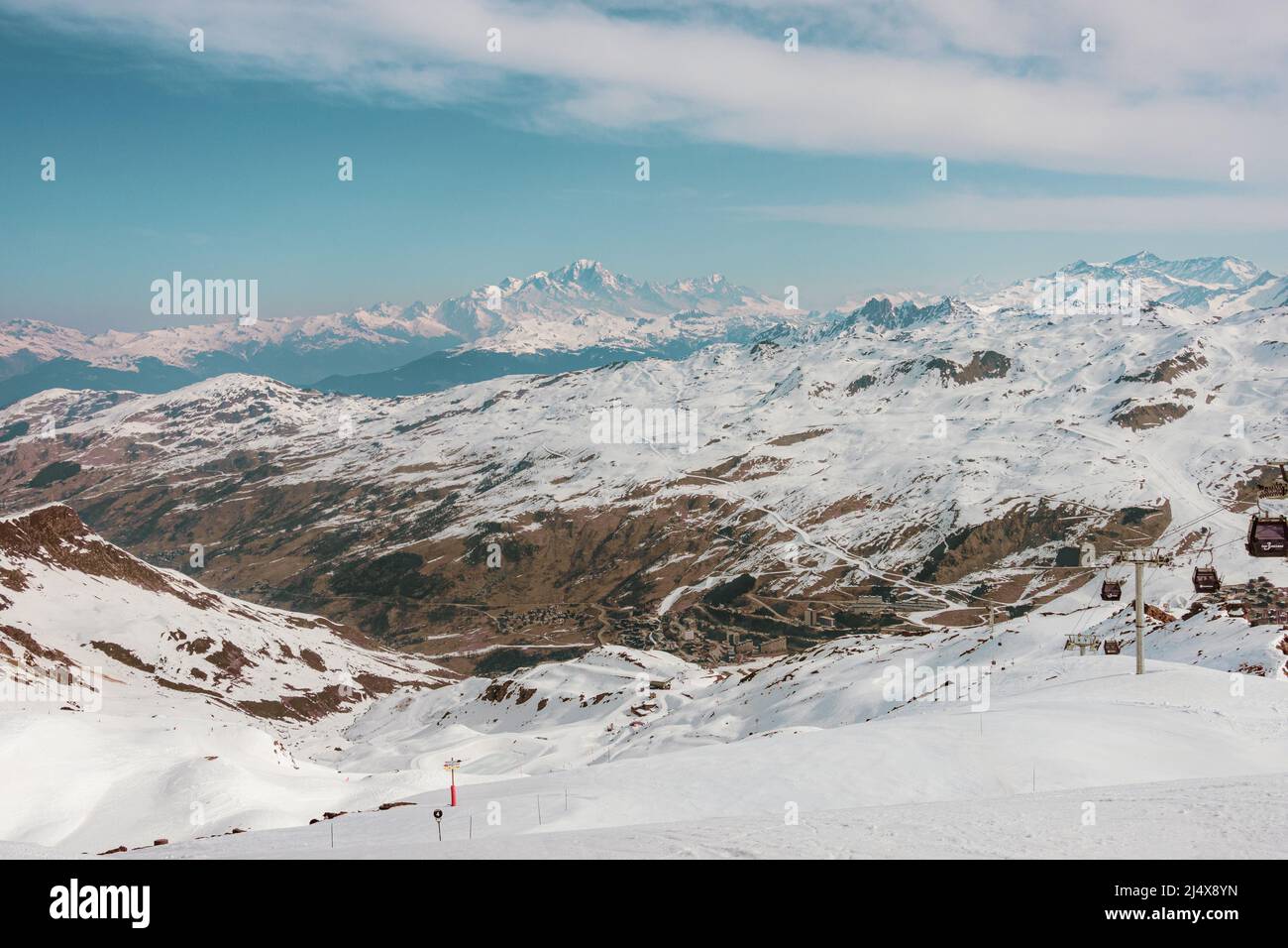 Ski slope and distant Mont Blanc mountain peaks under snow, French alps, highest mountain in Europa, Val Thorens Stock Photo