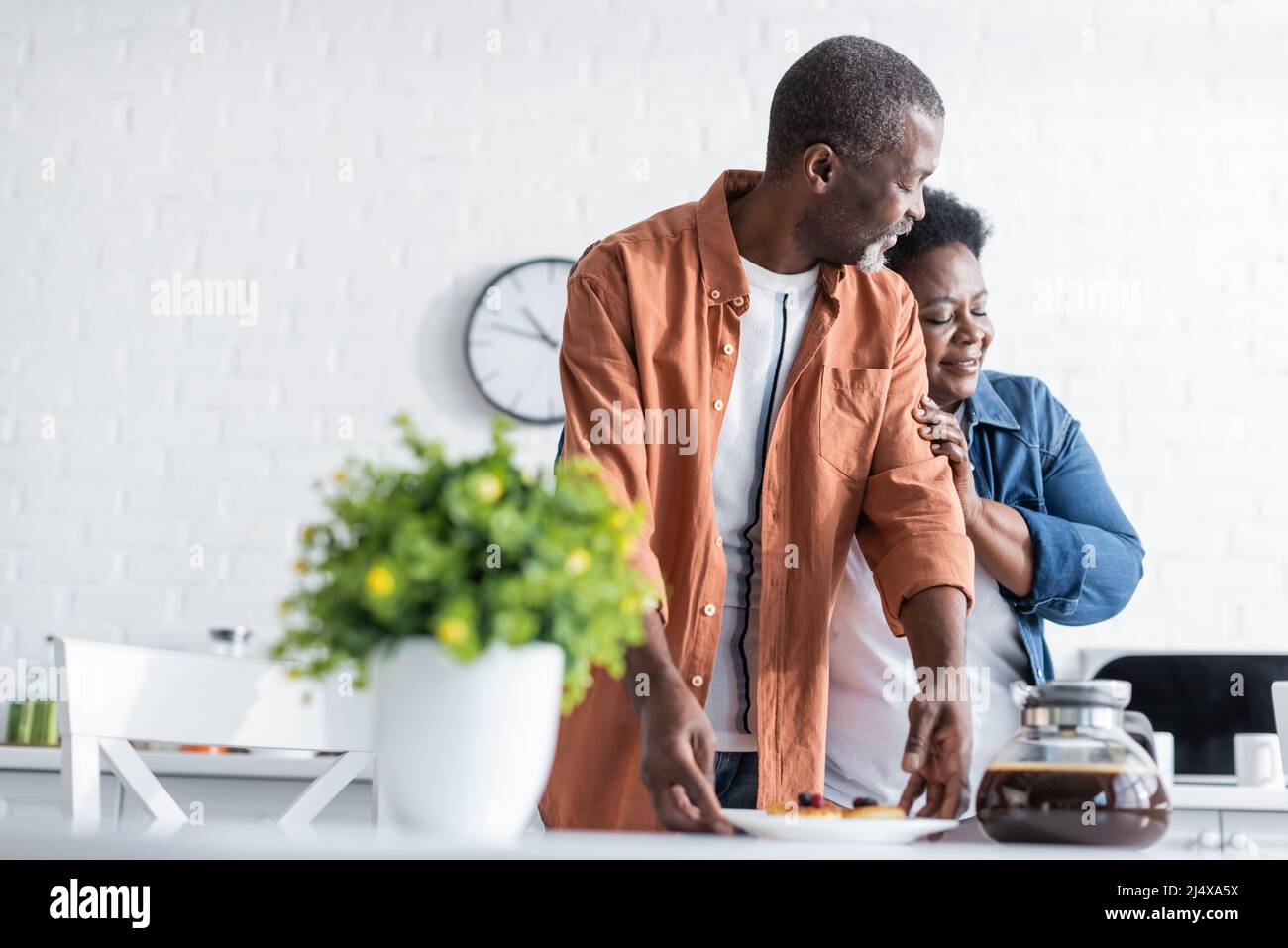 happy senior african american woman hugging husband near breakfast in ...