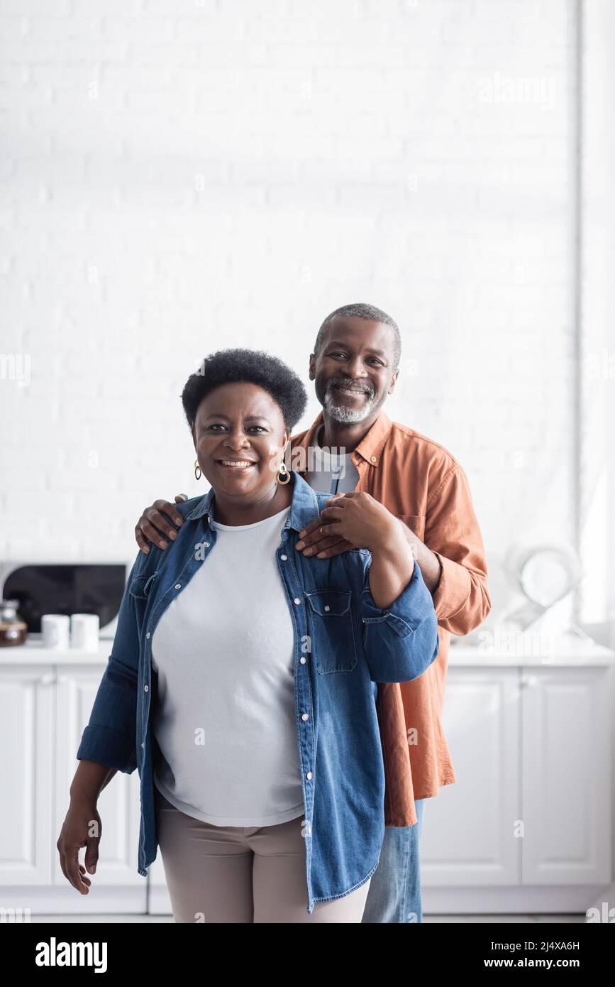 happy and senior african american man hugging cheerful wife Stock Photo ...