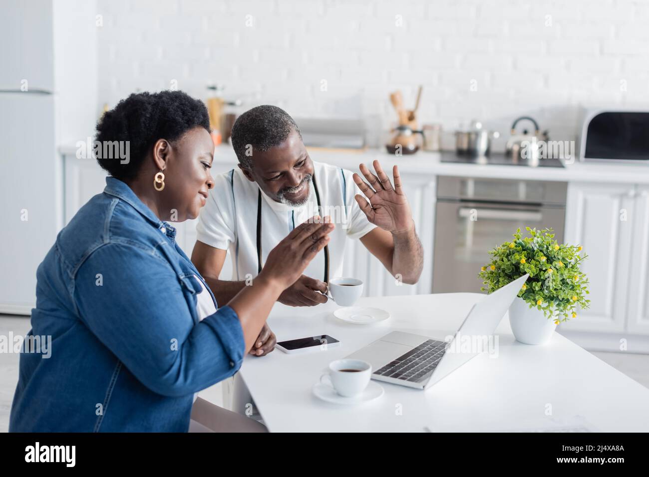 cheerful senior african american couple waving hands during video call ...