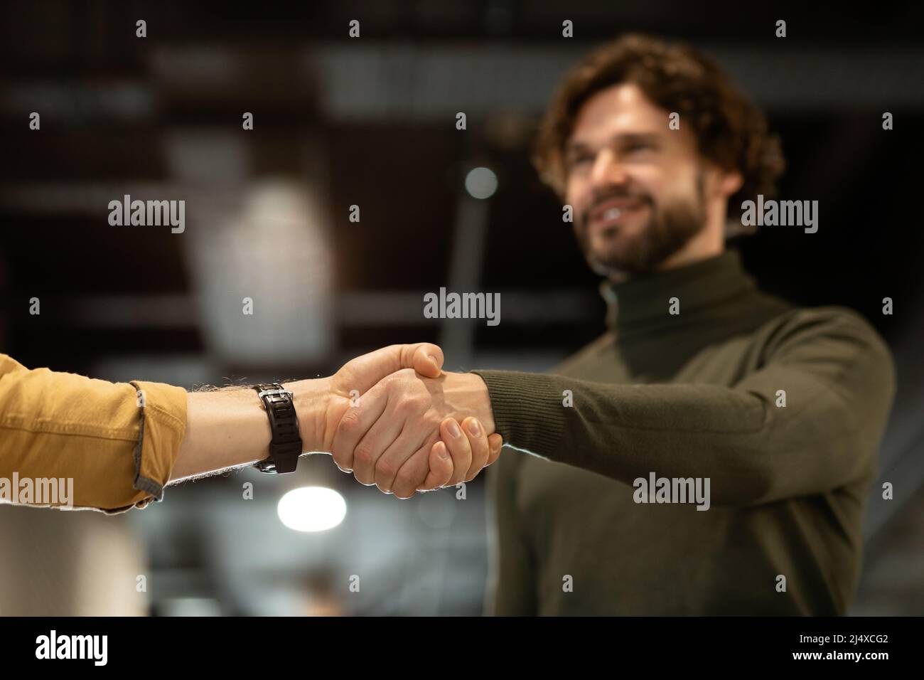 Contract conclusion and successful agreement. Happy entrepreneur shaking hands with his business partner at office Stock Photo