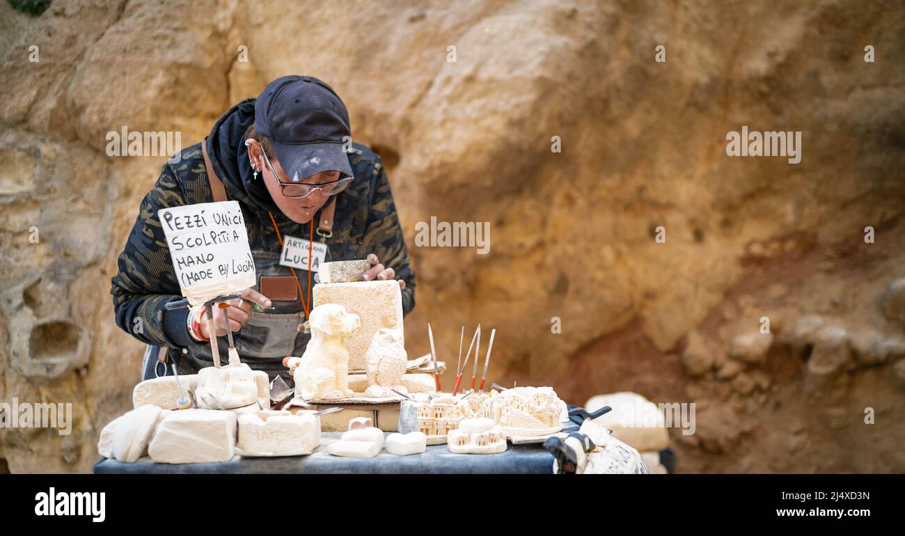 middle age woman carving stone to create objects ornaments stone Stock Photo