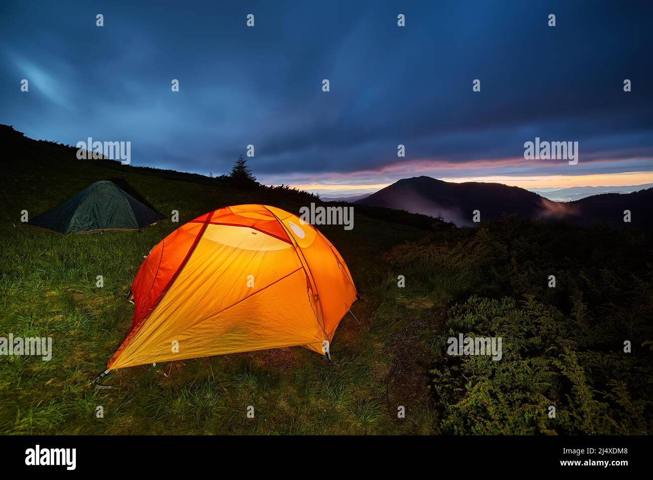 Illuminated orange camping tent under moon at night Stock Photo - Alamy