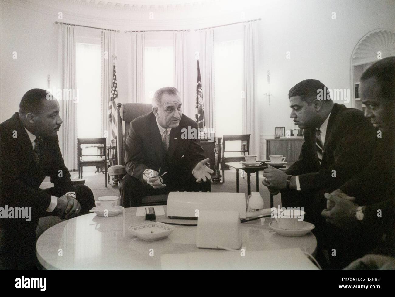 United States President Lyndon Baines Johnson LBJ speaking black civil rights leaders in the Oval Office taken on January 18, 1964 by Yoichi Okamoto, President Lyndon B. Johnson meets with a group of civil rights leaders. Among the group are the Rev. Dr. Martin Luther King, Jr. of the Southern Christian Leadership Conference (left), Whitney M. Young, Jr. of the National Urban League (right), and James Farmer of the Congress of Racial Equality (far right). Stock Photo