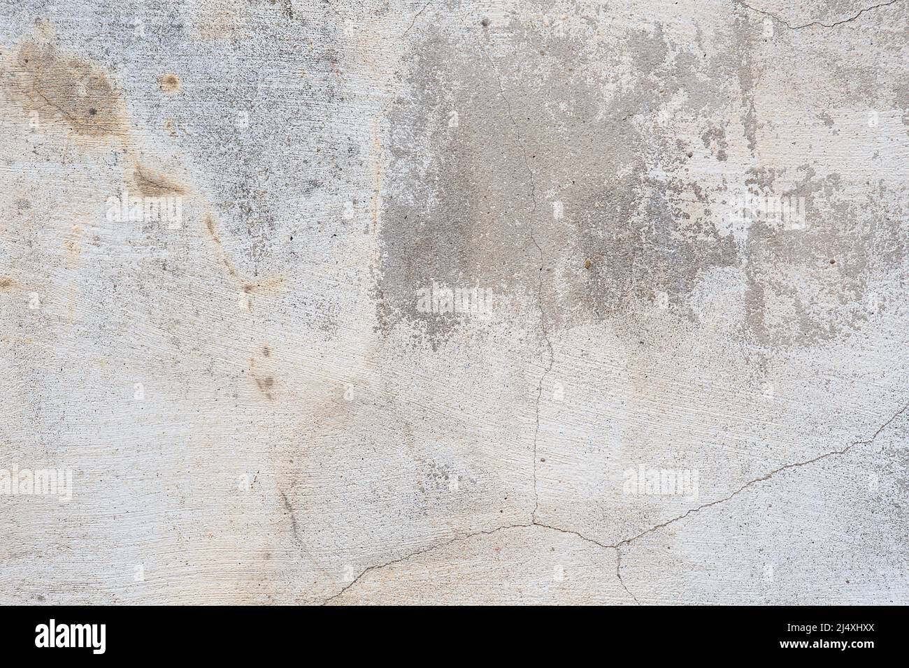 Old flaky wall with destroyed plaster. Renovation of old house. Industrial style design wall background. Grunge cracked concrete wall with old paint. Stock Photo