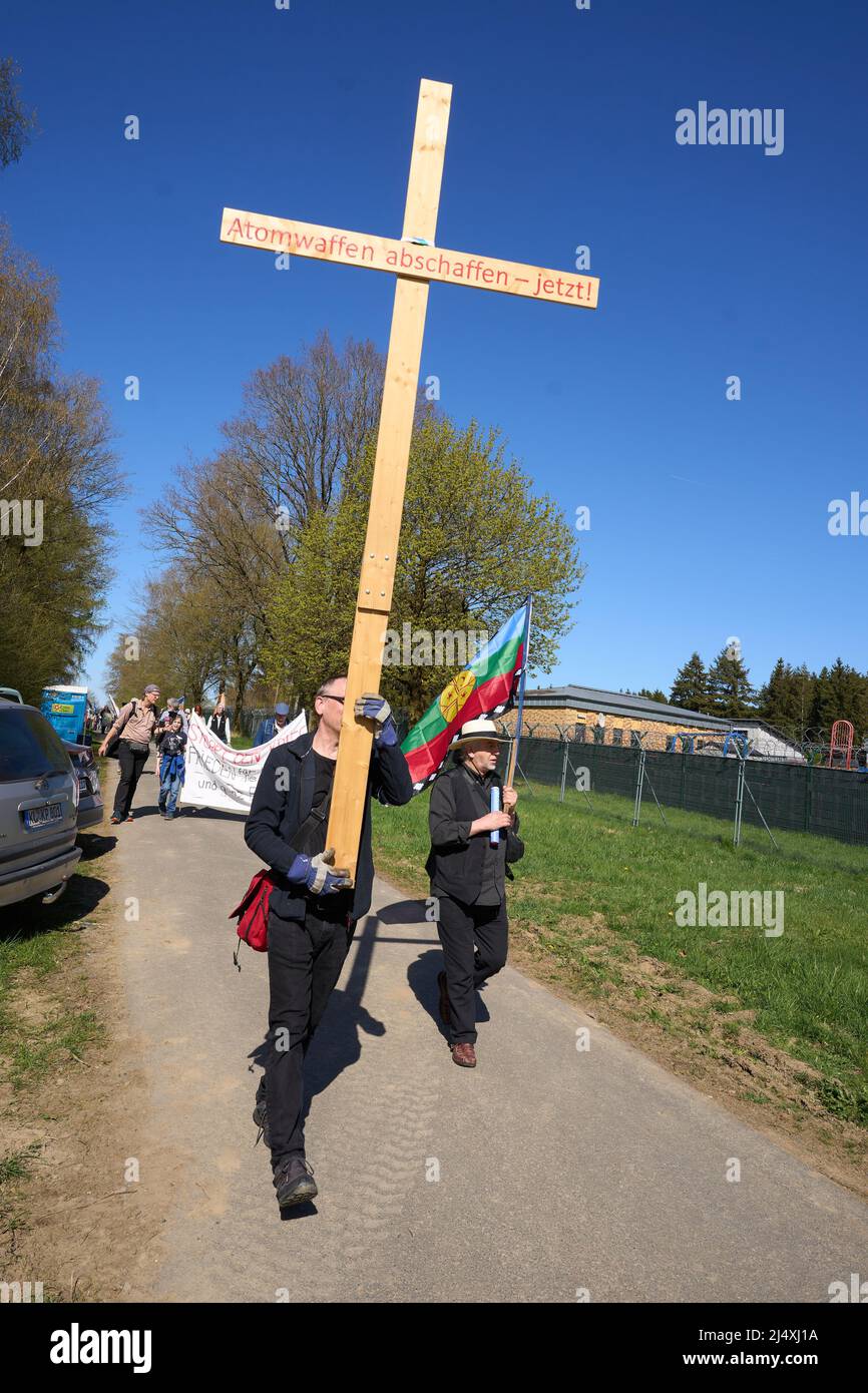 18 April 2022, Rhineland-Palatinate, Büchel: A participant of the Easter march carries a wooden cross. American nuclear weapons are to be stored at the Bundeswehr air base. Photo: Thomas Frey/dpa Stock Photo