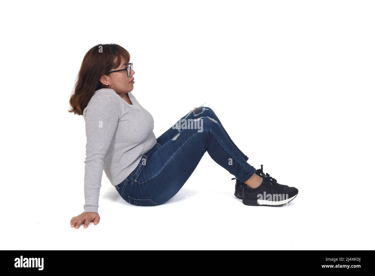 woman sitting on the floor on white background Stock Photo - Alamy