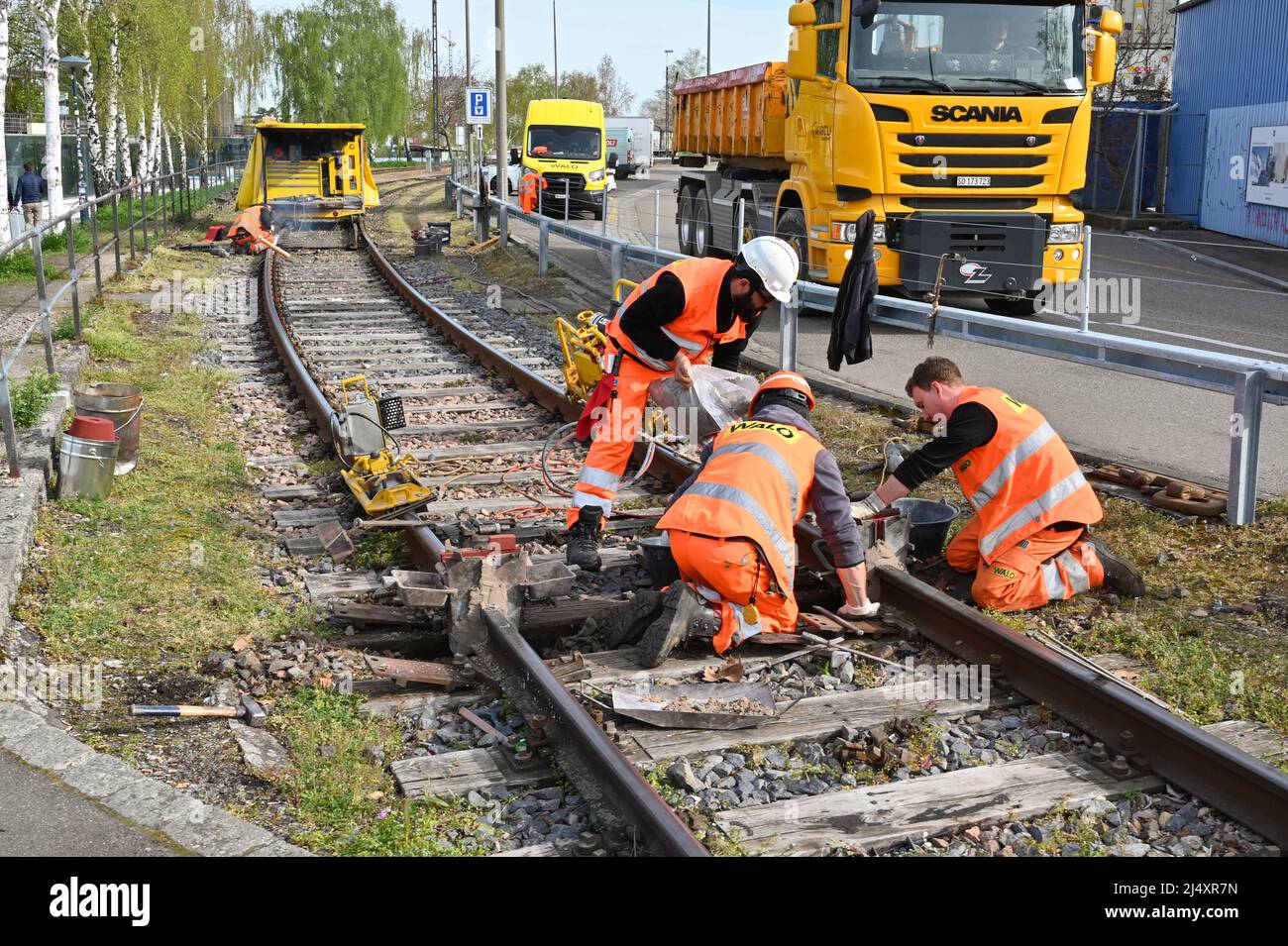 Basel, Switzerland - April 2022: Railway workers repairing track on a railway line in the city's docks area Stock Photo