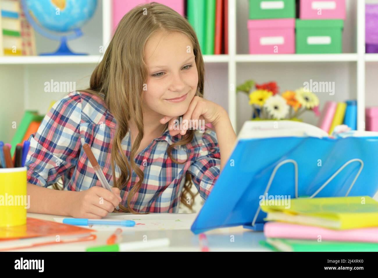 Cute girl doing her home work at desk Stock Photo - Alamy