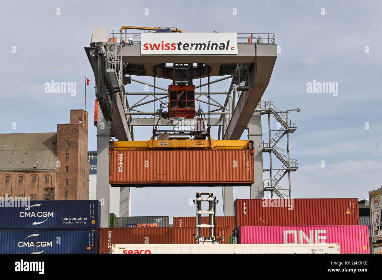 Basel, Switzerland April 2022 Heavy crane in the city's container terminal lifting a shipping