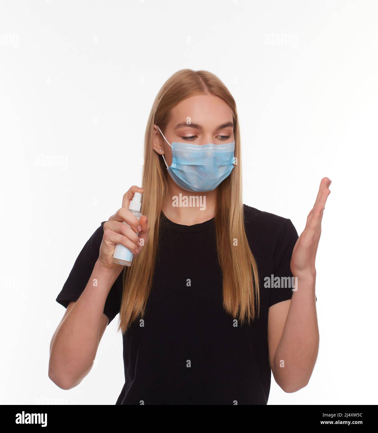 young girl in a protective medical mask on her face, holding a ...