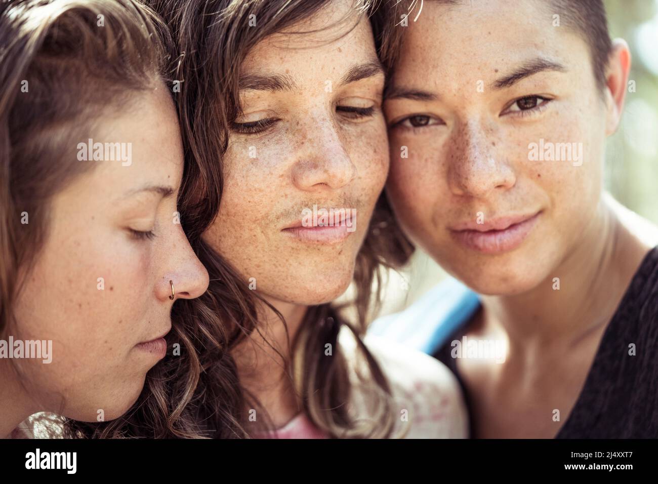 Polyamorous queer women thrupple connect in Portugal summer Stock Photo