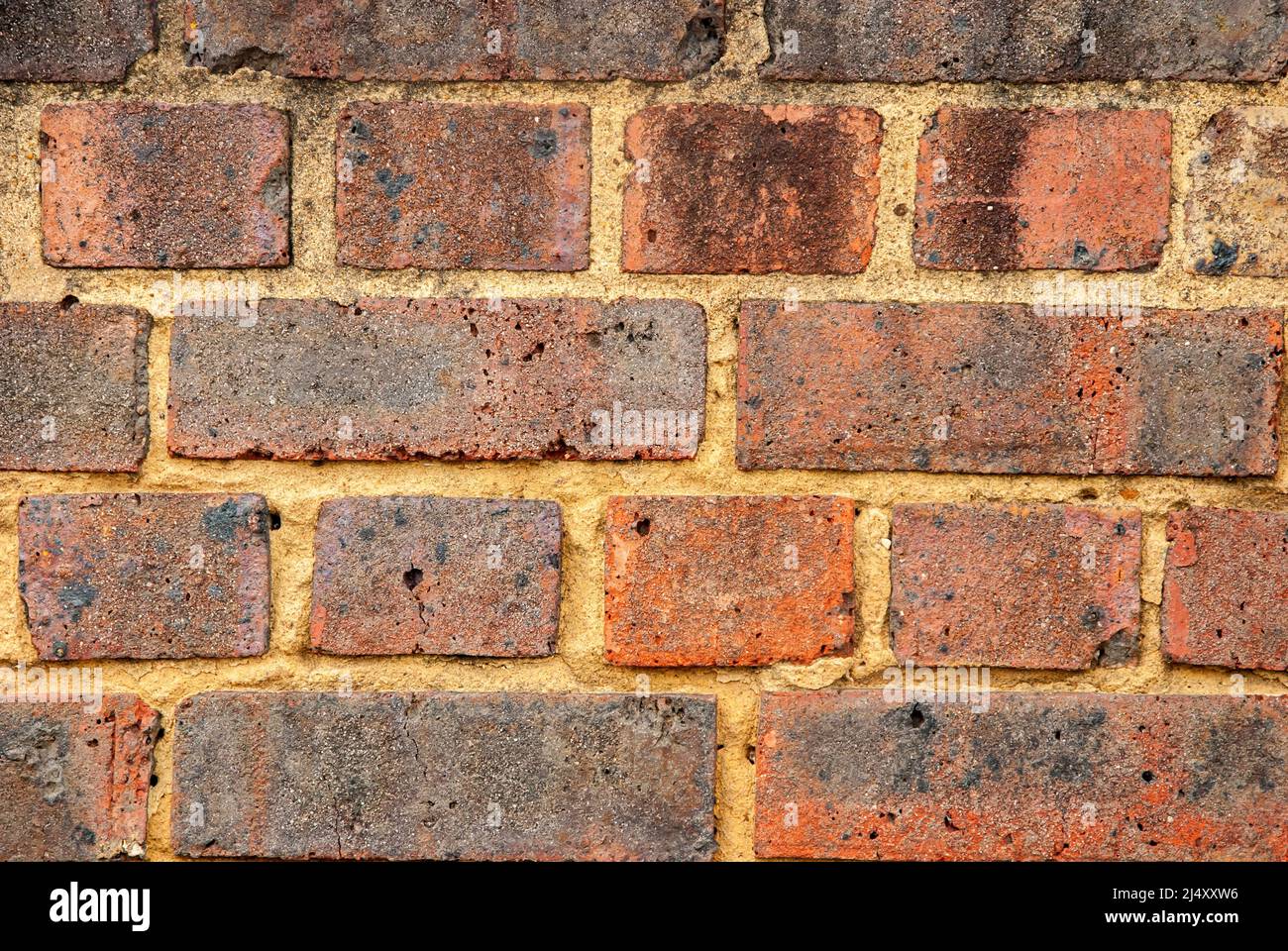Old weathered red brick wall closeup as background Stock Photo
