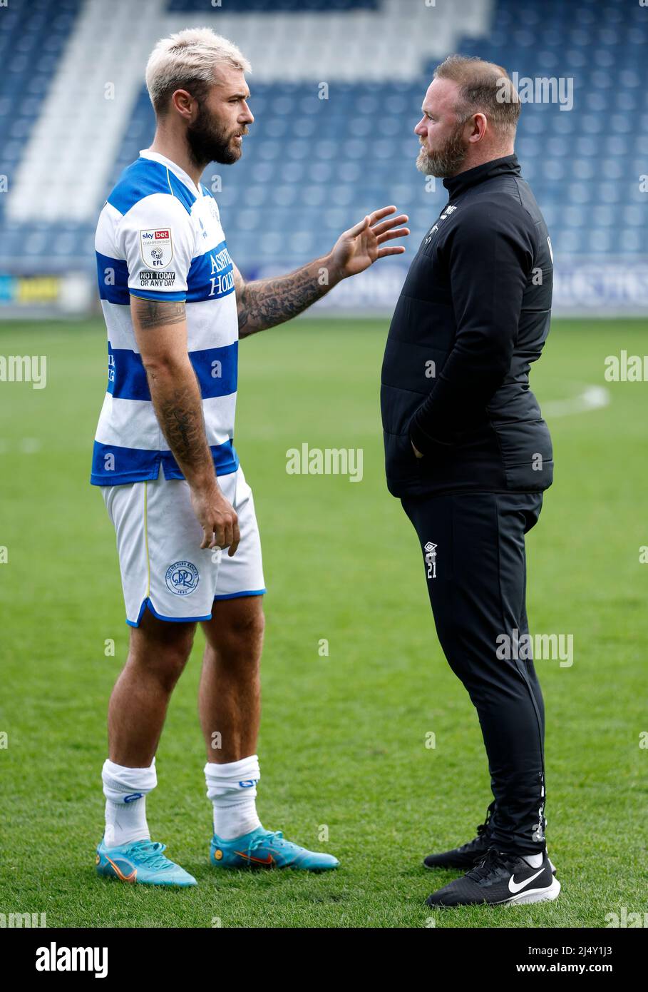 Queens Park Rangers' Charlie Austin speaks to Derby County manager Wayne Rooney following the Sky Bet Championship match at the Kiyan Prince Foundation Stadium, London. Picture date: Monday April 18, 2022. Stock Photo