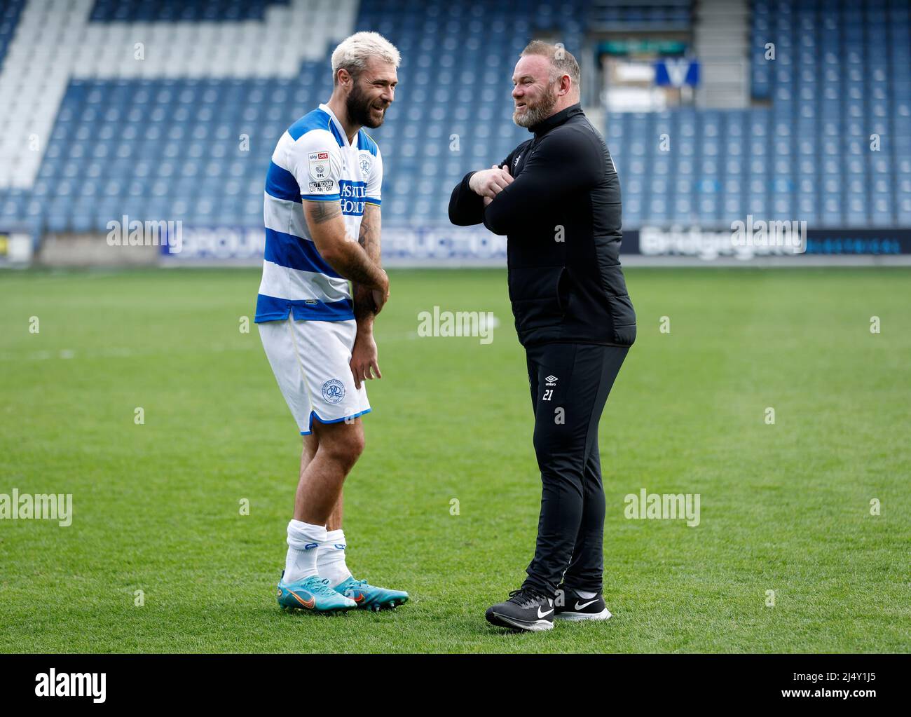 Queens Park Rangers' Charlie Austin speaks to Derby County manager Wayne Rooney following the Sky Bet Championship match at the Kiyan Prince Foundation Stadium, London. Picture date: Monday April 18, 2022. Stock Photo