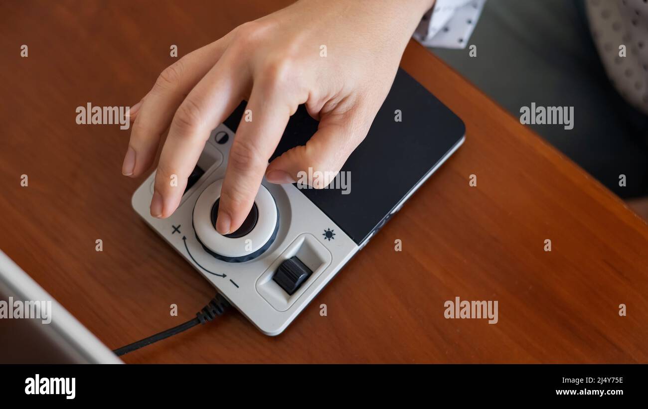 A woman uses a special magnification device for the visually impaired