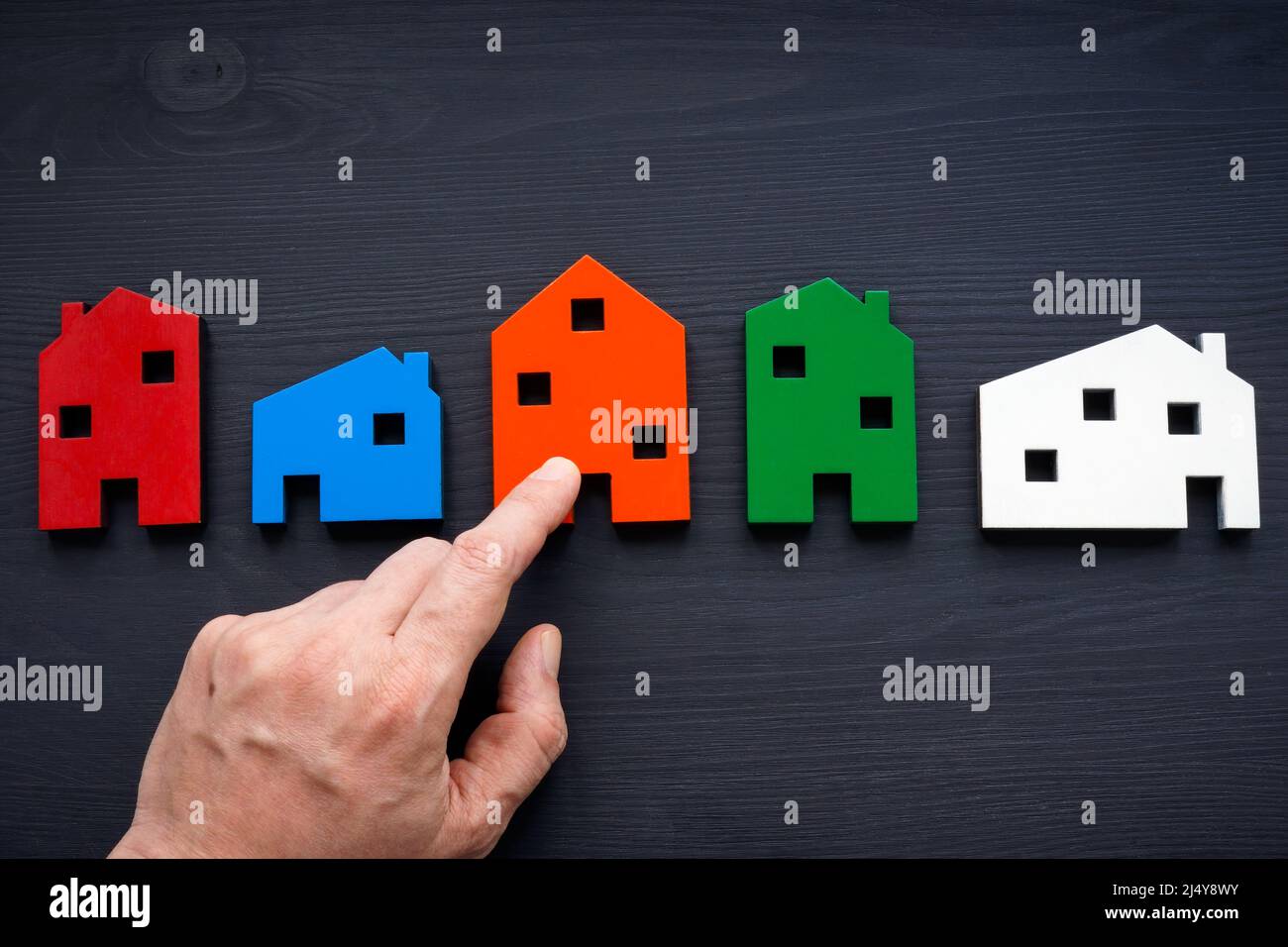 The choice of real estate concept. The hand points to the house Stock