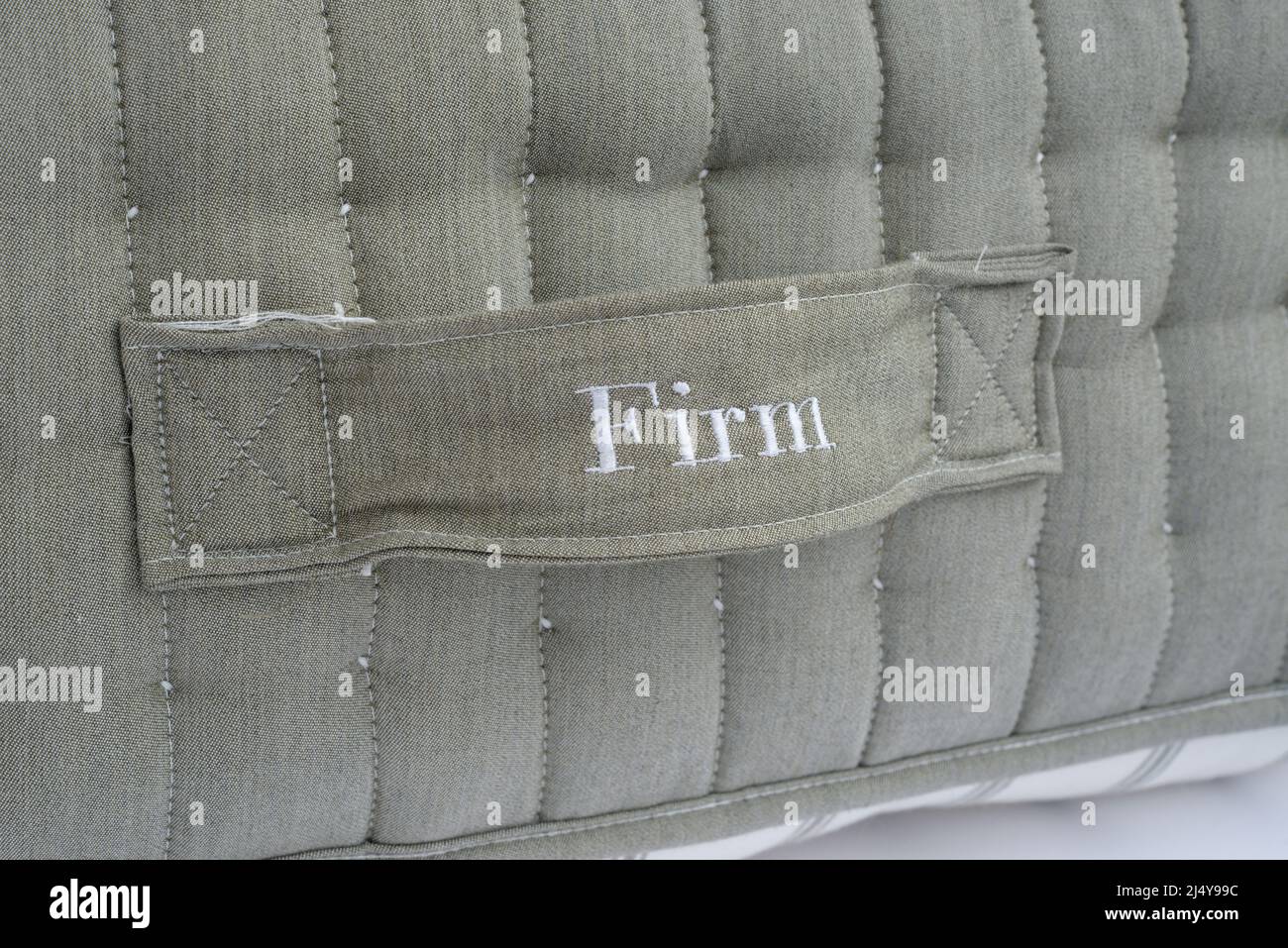 Mattress handle with the word Firm. A firm well supported mattress. Stock Photo