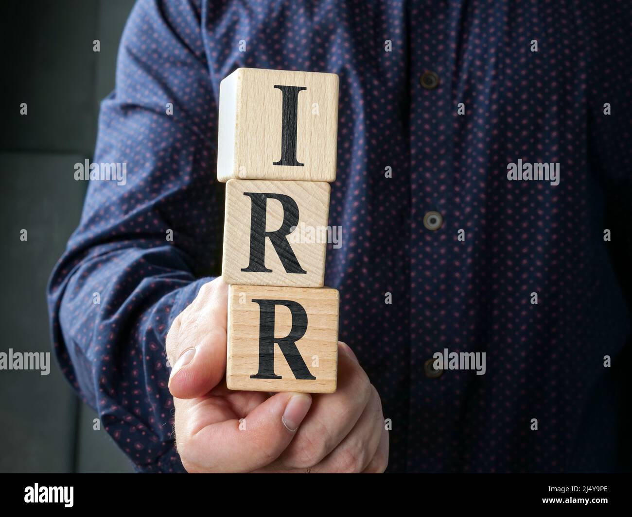 Hand holding cubes with abbreviation IRR Internal Rate of Return. Stock Photo