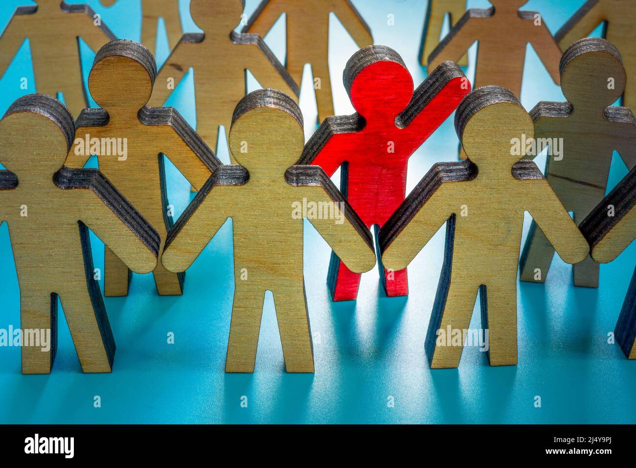 Be different and leader concept. A crowd of figurines and one red. Stock Photo