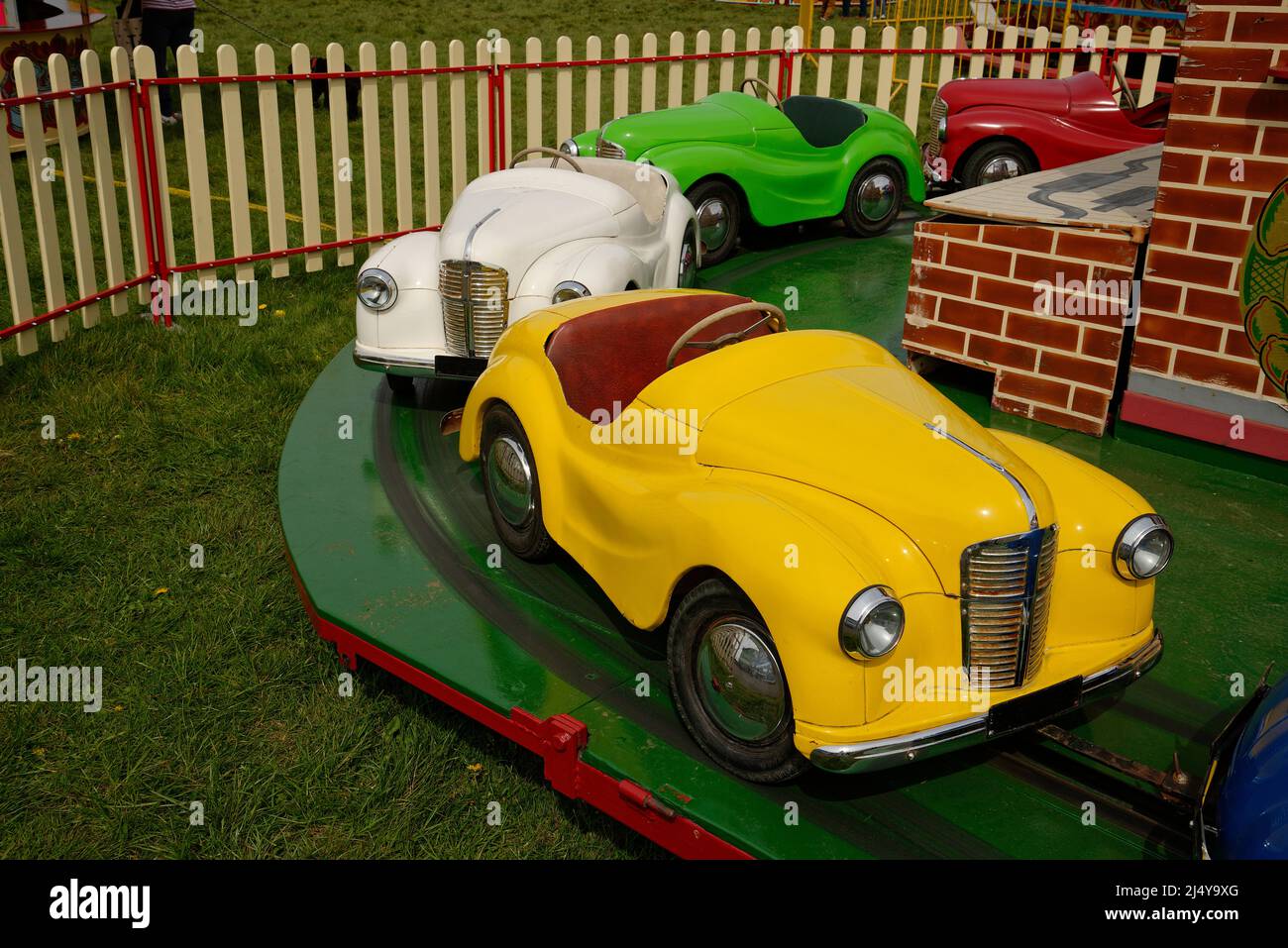 A fairground ride for children. Small 'cars' to steer and pretend to drive. Stock Photo