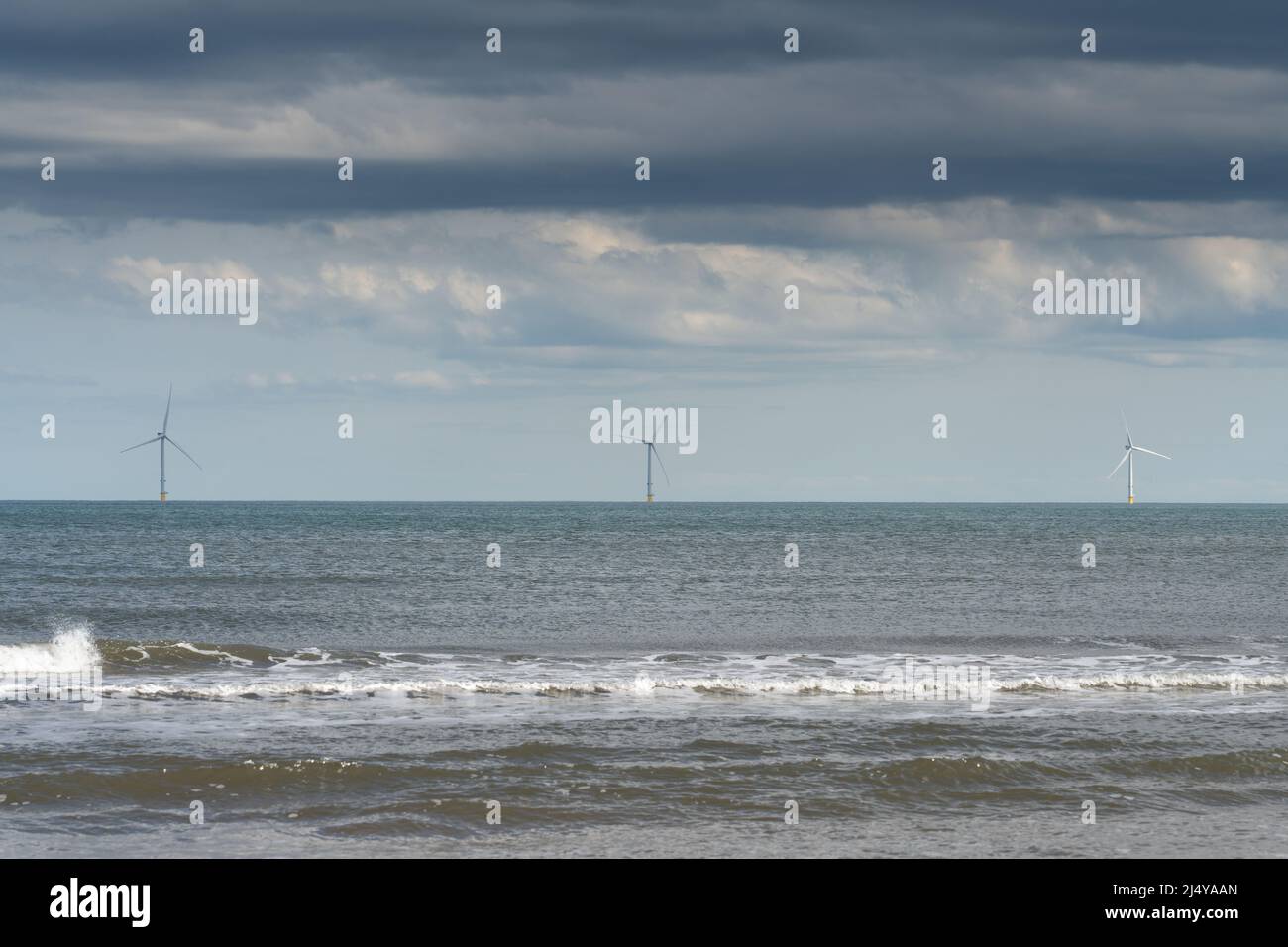 Offshore wind turbines seen from the beach at Cambois, Blyth, Northumberland, UK. Stock Photo