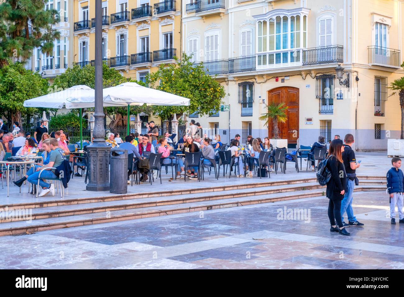 Large group of tourists sitting in the Plaza of the Virgin in the old town district. This area is a major tourist attraction. Valencia city is the cap Stock Photo