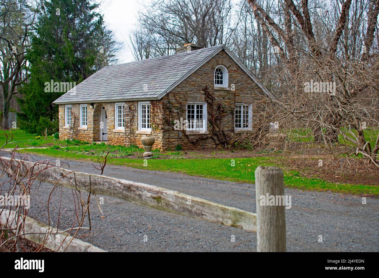 Rustic cabin with stone walls, surrounded by dormant vegetation in ...