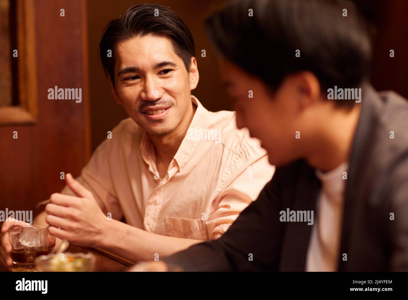Japanese friends having a drink at a bar counter Stock Photo Alamy