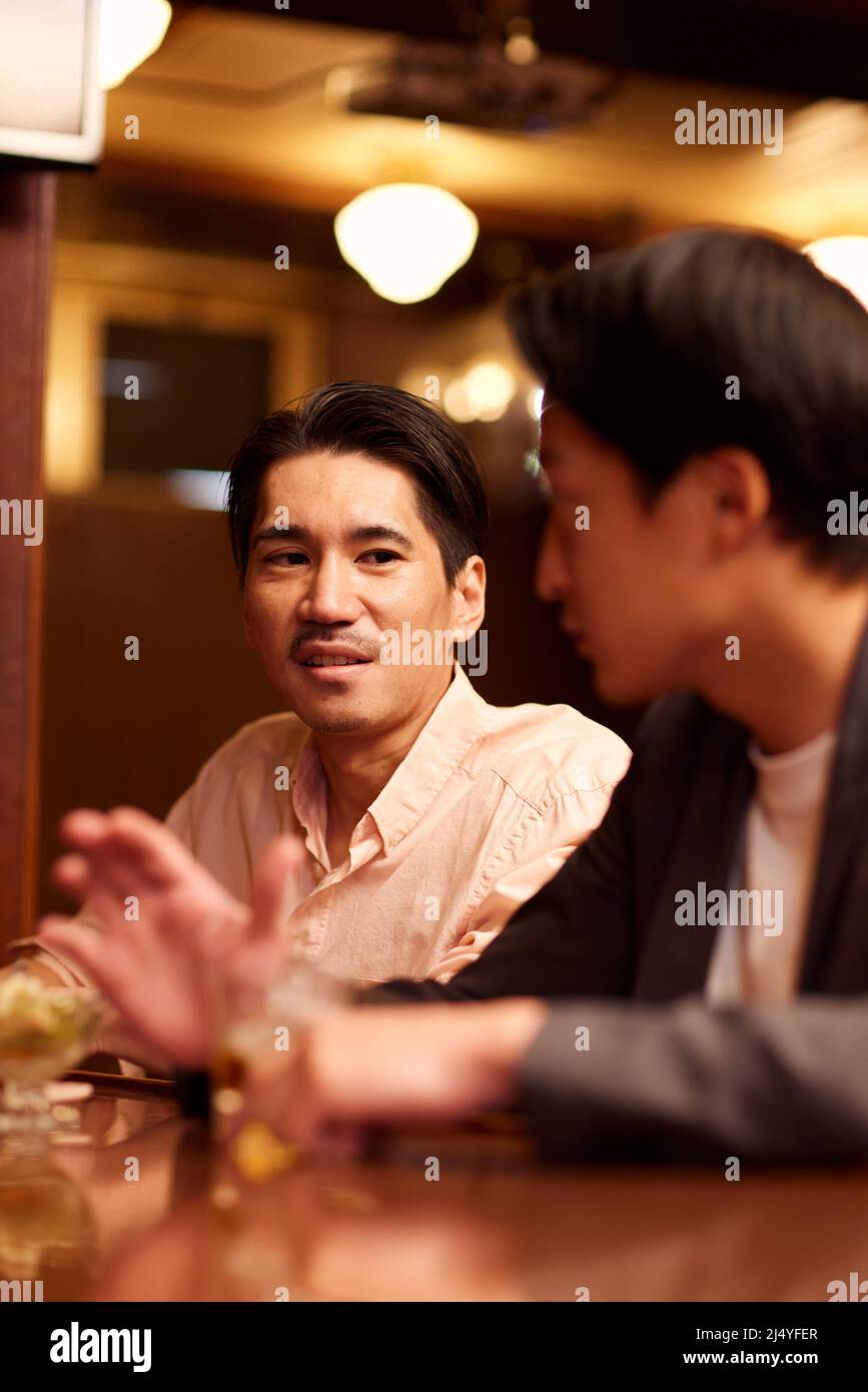 Japanese friends having a drink at a bar counter Stock Photo Alamy