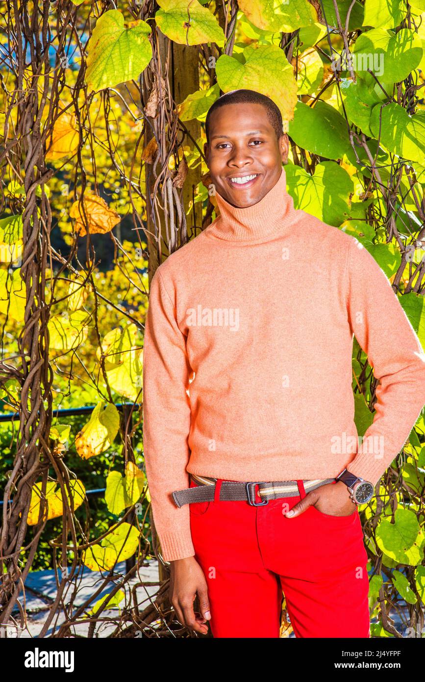 Man Autumn Casual Fashion. Dressing in light orange sweater with high  collar, red pants, patterned boot shoes, wearing wristwatch, a young black  guy i Stock Photo - Alamy