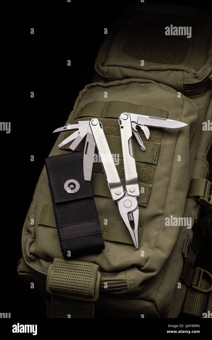 Modern multitool with many tools. A portable multitasking tool lie on a ...