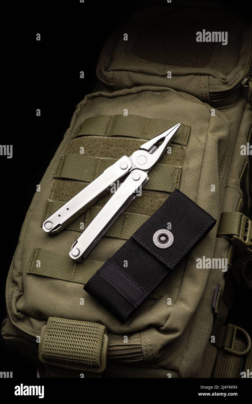 Modern multitool with many tools. A portable multitasking tool lie on a ...