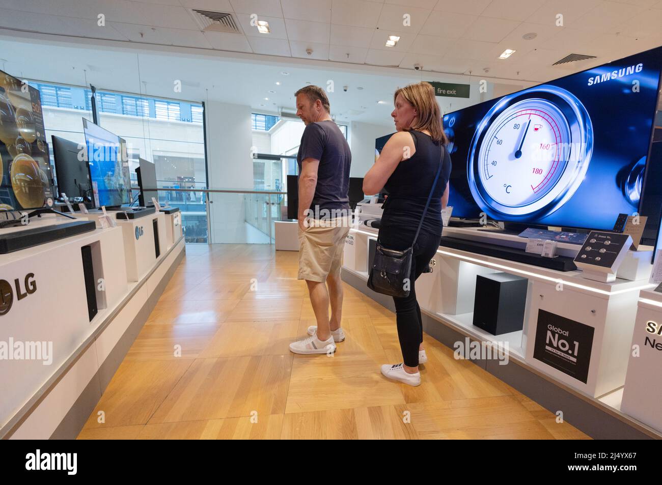 Couple buying a TV; people shopping for a new television, John Lewis store interior, Cambridge UK Stock Photo